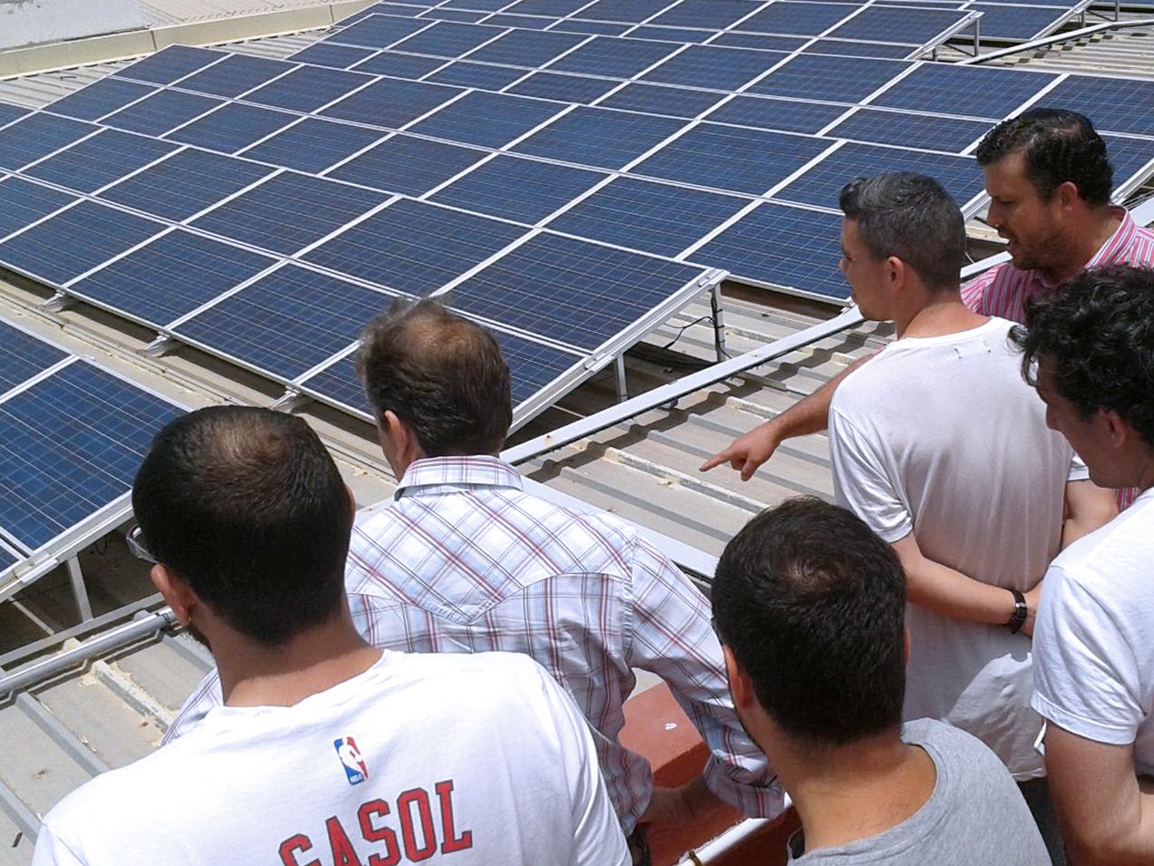 Alumnos junto al profesor estudiando una instalación solar fotovoltaica